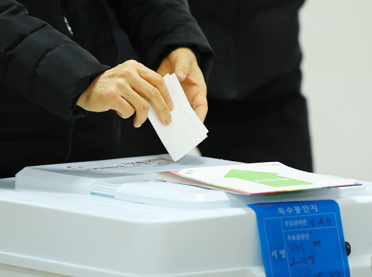5일 서울 광진구 자양 제3동 주민센터에 마련된 사전투표소를 찾은 시민이 투표함에 투표용지를 넣고 있다. 연합뉴스